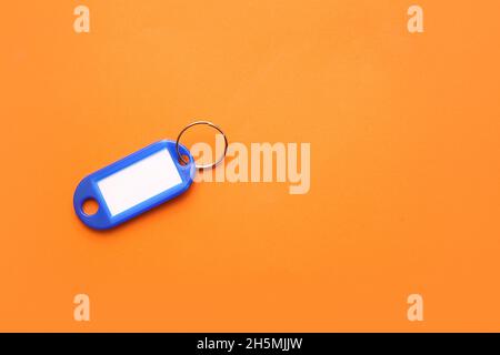 Étiquette de clé en plastique sur fond orange Banque D'Images