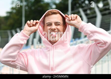 Jeune garçon drôle dans le sweat à capuche élégant en plein air Banque D'Images
