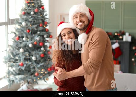 Joyeux couple qui fête Noël à la maison Banque D'Images