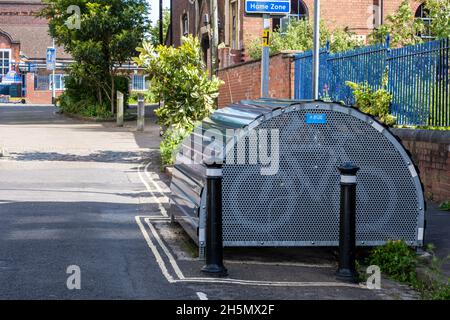 Les arbres et les plantes, ainsi qu'un parking à vélo sécurisé « Bike Hangar », contribuent à calmer la circulation dans une rue résidentielle de la « zone d'accueil » à Bristol. Banque D'Images