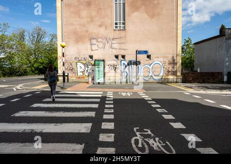 Un piéton traverse une rue en utilisant un cycle parallèle et une traversée en zébrée sur la voie verte de Filwood à Bedminster, Bristol. Banque D'Images