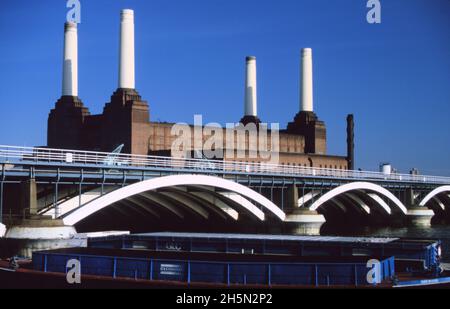 1986 MAI : ancienne centrale électrique de Battersea, pont ferroviaire de Grosvenor et barges d'évacuation des déchets GLC Cleanway sur la Tamise avec un ciel bleu à Londres, en Angleterre Banque D'Images