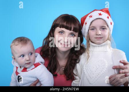 Jeune mère avec deux enfants portant des casquettes de Noël Banque D'Images