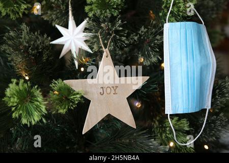 Décoration d'étoile de joie et de masque de visage accrochée sur l'arbre de Noël Banque D'Images