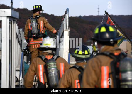 211110-N-GR655-080 GROTON, Connecticut (10 novembre 2021) – des pompiers de Norwich, Connecticut, franchissent l'arc de l'USS Cheyenne (SSN 773) lors d'un exercice d'intervention d'incendie à grande échelle à bord de la base sous-marine navale de New London à Groton, Connecticut, le 10 novembre 2021.L'exercice, organisé par NSSF (NSSF) New London, Cheyenne, et la direction de la base, a offert à plus d'une douzaine d'organisations régionales de pompiers et de premiers intervenants l'occasion de faire l'expérience de la lutte contre les incendies à bord des navires et des meilleures pratiques de la Marine.(É.-U.Photo de la Marine par Joshua Karsten, Chief Petty Officer/RELÂCHÉ) Banque D'Images