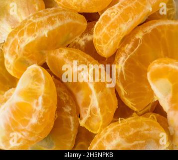 mandarines, tranches ou morceaux d'orange mandarin frais, fond d'agrumes, macro gros plan Banque D'Images