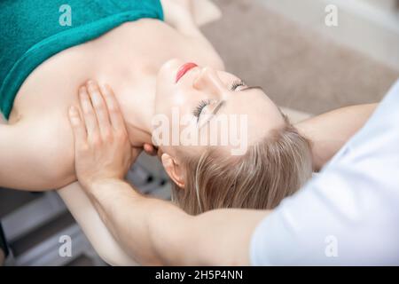 Thérapeute ostéopathie travaillant massage sportif avec les épaules de la femme athlète. Banque D'Images