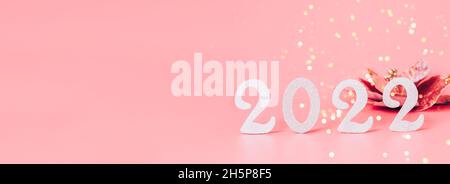 Composition festive de Numbers 2022 jouets du nouvel an fond rose pastel.Nouvelle année 2022, mise en page de la carte de vœux avec bannière Banque D'Images
