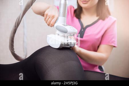 La femme reçoit un massage GPL pour enlever la cellulite de son corps, pour lever les jambes. Salon de beauté concept. Banque D'Images