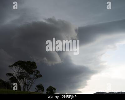 Les nuages de tempête, orageux gris et évolution rapide des conditions météorologiques, avant la grêle, se démarquent d'un ciel lumineux, sur la côte de Nouvelle-Galles du Sud, en Australie Banque D'Images