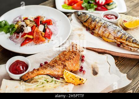 maquereau grillé et bar.Salade de légumes frais.Service sur une planche en bois sur une table rustique.Menu du restaurant barbecue, une série de photos de Banque D'Images