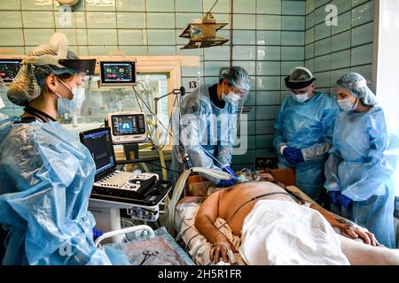 ZAPORIZHHIA, UKRAINE - 10 NOVEMBRE 2021 - les travailleurs de la santé des EPI examinent les poumons du patient par échographie dans l'USI COVID-19 de Zaporizhjhia Hospit Banque D'Images