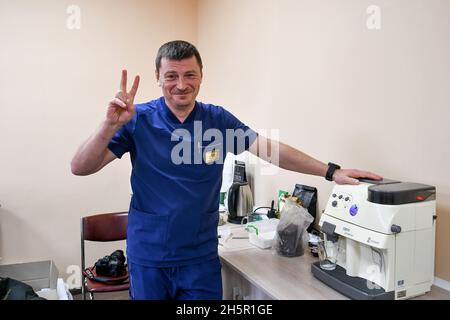 ZAPORIZHHIA, UKRAINE - 10 NOVEMBRE 2021 - le chef du département des soins intensifs Oleksandr Viedienieiev donne le V-sign à l'hôpital Zaporizhzhia N9, Banque D'Images