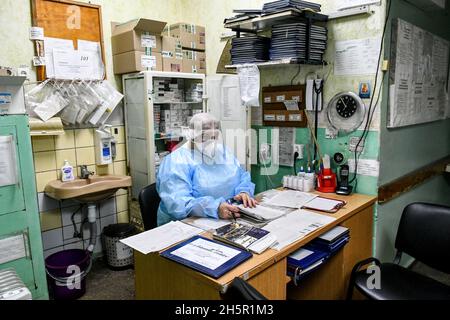 ZAPORIZHIA, UKRAINE - 10 NOVEMBRE 2021 - Un professionnel de la santé de l'EPI est assis au bureau de l'USI COVID-19 de l'hôpital Zaporizhzhia N9, Zaporizhzhia, Banque D'Images