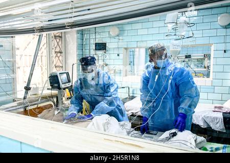 ZAPORIZHHIA, UKRAINE - 10 NOVEMBRE 2021 - les médecins en PPE séjournent par un patient dans l'unité de soins intensifs COVID-19 de l'hôpital Zaporizhzhia N9, Zaporizhzhia, southeaste Banque D'Images