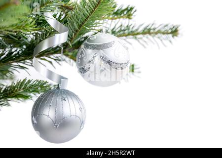 Boules d'argent décorations de Noël boules sur une branche d'épicéa sur un fond blanc Banque D'Images