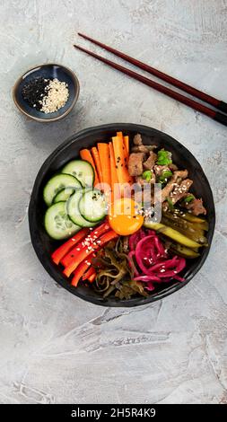 Bibimbap avec en-cas sur fond gris.Cuisine traditionnelle coréenne.Vue de dessus, plat, espace de copie Banque D'Images