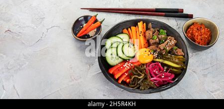 Bibimbap avec en-cas sur fond gris.Cuisine traditionnelle coréenne. Espace copie, panorama Banque D'Images