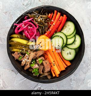 Bibimbap avec en-cas sur fond gris.Cuisine traditionnelle coréenne.Vue de dessus, plat, espace de copie Banque D'Images