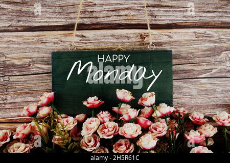 Joyeux lundi texte typographique avec bouquet de fleurs roses sur fond de bois Banque D'Images