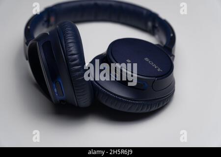 Gros plan d'un casque circum-aural Sony bleu foncé isolé sur un fond gris Banque D'Images