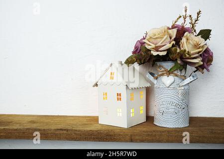 étagères en bois décorées de bougeoirs blancs et de fleurs roses Banque D'Images