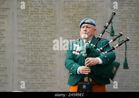 Christy O'Brien, joueur de cornemuse auprès de l'United Nation's Veterans Association, joue les cornemuses devant un mémorial pour ceux qui sont morts pendant la Grande Guerre avant un silence de deux minutes le jour de l'Armistice au cimetière de Glasnevin à Dublin.Date de la photo: Jeudi 11 novembre 2021. Banque D'Images