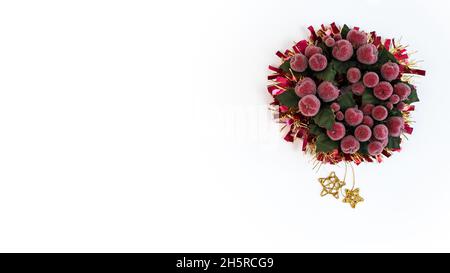 Belle couronne de feuilles de houx avec Noël scintillant et espace pour le texte.Guirlande de Noël en ruban avec décorations traditionnelles aux baies rouges isolées sur le blanc Banque D'Images