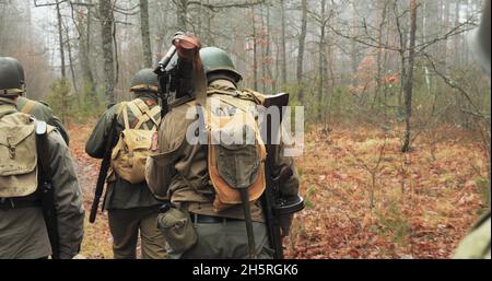 Reconstitution historique.Des réacteurs habillés comme soldats américains de l'infanterie américaine de la Seconde Guerre mondiale marchant le long de Forest Road le jour de l'automne Banque D'Images