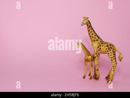Girafe en plastique marron sur fond rose.Copier l'espace. Banque D'Images