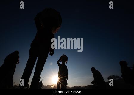 Katmandou, Népal.11 novembre 2021.Les adeptes de la silhouette se déplacent vers leurs maisons tout en portant des offrandes après avoir conclu le festival Chhath sur la rive du Saint fleuve Bagmati.dans un ancien festival hindou, des rituels sont exécutés pour remercier le Dieu du soleil pour avoir soutenu la vie sur terre.Chhath Puja est un festival hindou où les dévots prient dieu et offrent Prasad et des spécialités spéciales au coucher du soleil et avant le lever du soleil et de terminer leur jeûne en mangeant 'Prasad' et des spécialités spéciales.(Photo de Prabin Ranabhat/SOPA Images/Sipa USA) crédit: SIPA USA/Alay Live News Banque D'Images