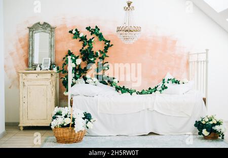 Intérieur d'une chambre blanche et lumineuse avec des fleurs décoratives sur un mur. Banque D'Images