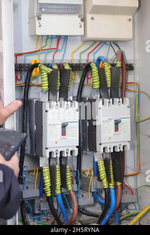 Technicien effectuant la lecture du compteur sur les câbles électriques pour le kilowatt-heure Banque D'Images