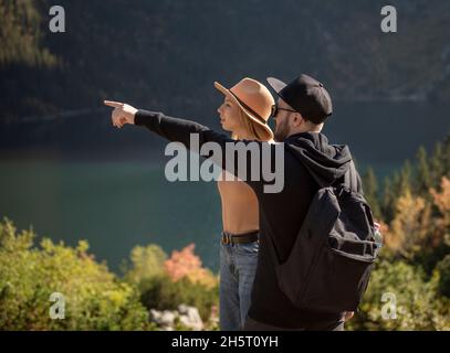 Jeune couple voyageant dans les montagnes.Un homme pointe sur la montagne avec un arrière-plan naturel Banque D'Images