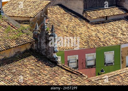 Toits de vieilles maisons et églises de style colonial vus d'en haut et portés par le temps dans le quartier Pelourinho de Salvador, Bahia Banque D'Images