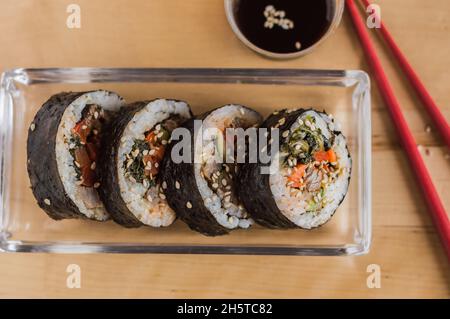 Coupez le kimbap ou le gimpab. Rouleaux traditionnels coréens avec du riz, du bœuf, des légumes et de l'omelette Banque D'Images