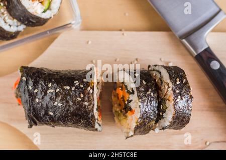 Coupez le kimbap ou le gimpab. Rouleaux traditionnels coréens avec du riz, du bœuf, des légumes et de l'omelette Banque D'Images