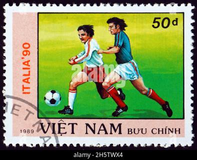 VIETNAM - VERS 1989 : un timbre imprimé au Vietnam montre le joueur de football en action, coupe du monde de football 1990 Championnats, Italie, vers 1989 Banque D'Images
