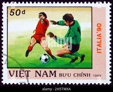 VIETNAM - VERS 1989 : un timbre imprimé au Vietnam montre le joueur de football en action, coupe du monde de football 1990 Championnats, Italie, vers 1989 Banque D'Images