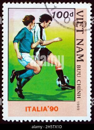 VIETNAM - VERS 1989 : un timbre imprimé au Vietnam montre le joueur de football en action, coupe du monde de football 1990 Championnats, Italie, vers 1989 Banque D'Images