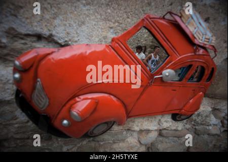 BESALU, ESPAGNE - 6 AOÛT 2021 : reflets des citadins dans un miroir en forme de voiture inhabituel Banque D'Images