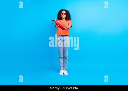 Photo pleine longueur de la jeune femme africaine sourire positif heureux feu protection de chasse isolée sur fond bleu de couleur Banque D'Images