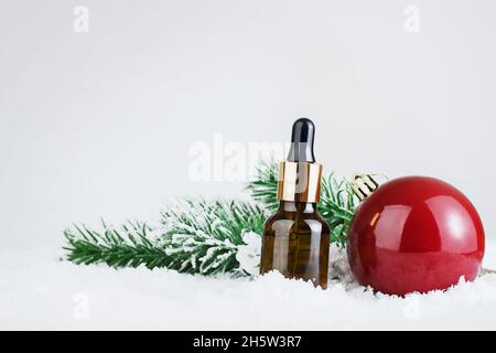 Maquette de bouteille en verre compte-gouttes.Flacon avec bouchon.Concept de la cosmétologie et de la beauté.Cosmétiques d'hiver.Cadeaux pour Noël ou le nouvel an.Publicité vierge Banque D'Images
