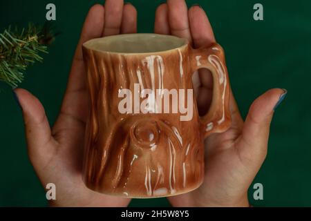 mains d'une personne tenant une tasse de verre avec texture de bois, objets originaux et délicats en studio, papier peint d'articles ménagers Banque D'Images