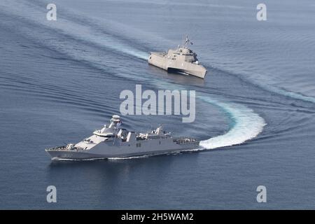 La frégate de classe Martininata de la marine indonésienne KRI I Gusti Ngurah Rai, a quitté, lors d'un exercice passant avec le navire de combat littoral de la variante de l'indépendance de la marine américaine USS Jackson, à droite, pendant la coopération afloat et la préparation et l'entraînement 9 novembre 2021 dans la mer de Java. Banque D'Images