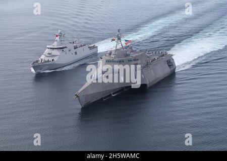 La frégate de classe Martininata de la Marine indonésienne KRI I Gusti Ngurah Rai navigue le long du navire de combat littoral de la variante indépendance de la Marine américaine USS Jackson, à droite, pendant la coopération et la préparation et l'entraînement novembre 9, 2021 dans la mer de Java. Banque D'Images