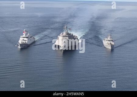 Le navire de combat littoral USS Jackson, au centre, de la Marine américaine, s'embarque avec la frégate KRI I Gusti Ngurah Rai de la Marine indonésienne, et la corvette KRI Diponegoro de la classe Diponegoro pendant la coopération et la préparation et l'entraînement 9 novembre 2021 dans la mer de Java. Banque D'Images