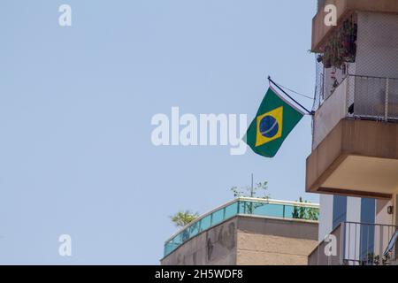 Drapeau brésilien sur la fenêtre d'un bâtiment à Rio de Janeiro. Banque D'Images