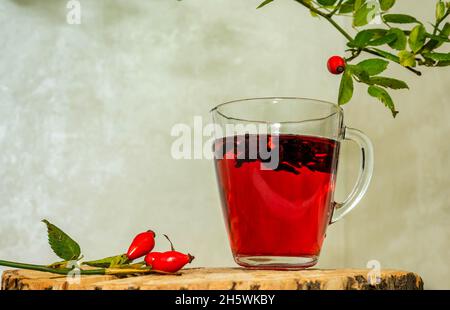 Thé naturel de baies de roses sauvages sur des planches de bois.Traitement de l'homéopathie des baies rouges. Banque D'Images