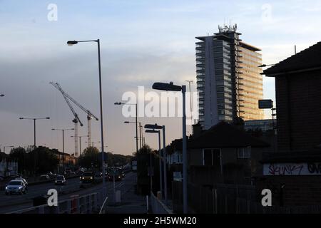 Trafic intense sur la voie de contournement de l'A3 avec la tour Tolworth silhouetted au coucher du soleil avec circulation tôt le soir. Banque D'Images